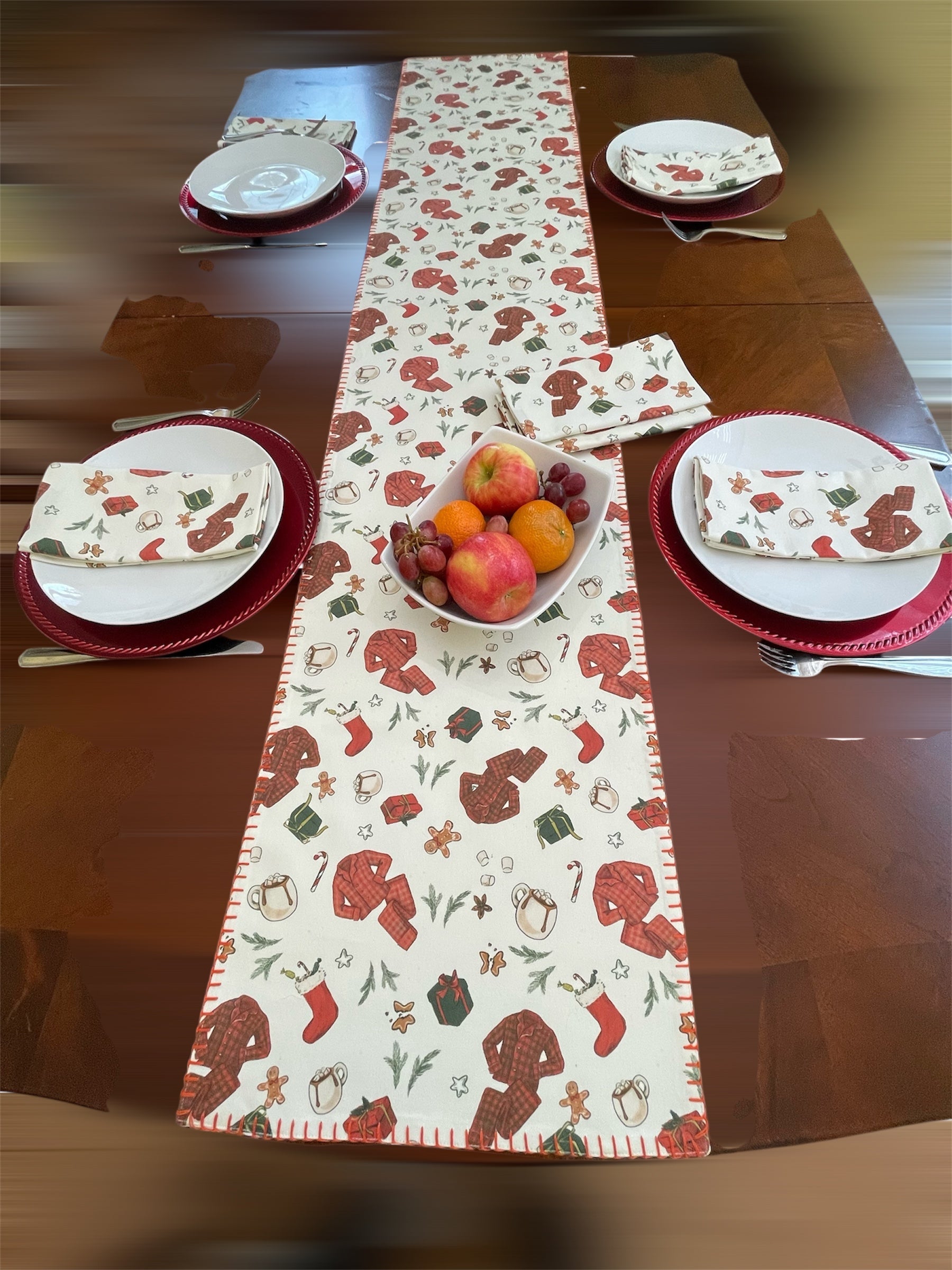 Table setting with a festive table runner featuring winter-themed designs.