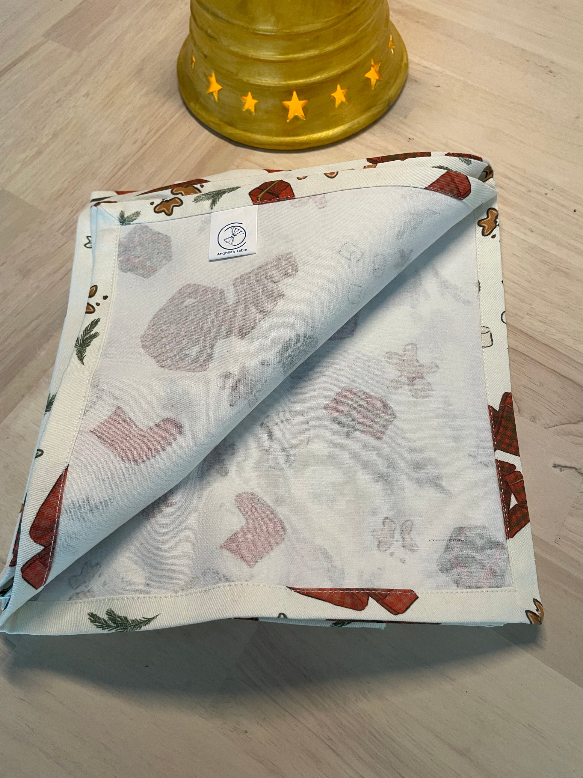 Festive cotton napkins featuring cozy Christmas morning scene with stockings, wrapped gifts, cocoa, and cookies.