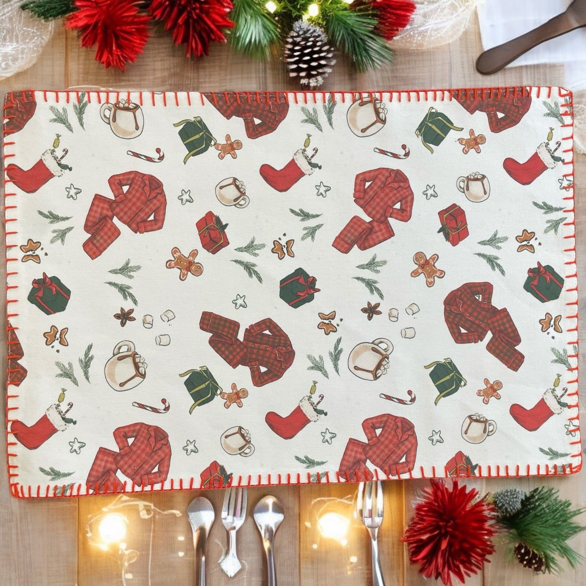 Anghild's Table Placemat Christmas Morning Placemats set of 2 Christmas Morning Placemats set of 2 Anghild's Table Christmas Morning Cotton placemat with chritmas morning motif of buffalo check PJs, candy canes, Christmas  stockings, wrapped gifts and Christmas cookies on an off white background and red whip sticking trim.