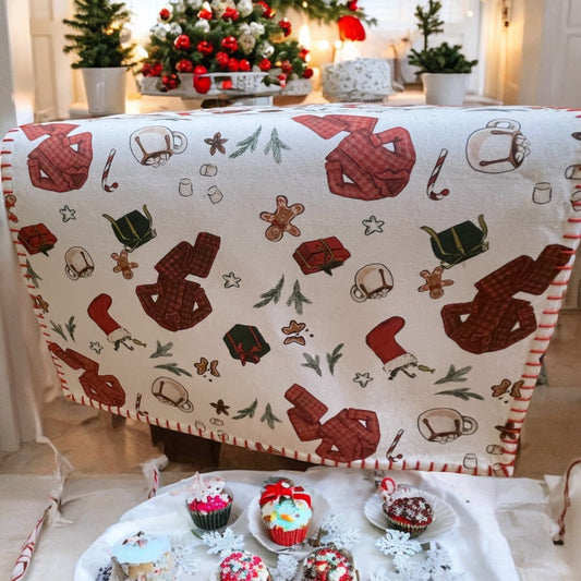 Anghild's Table Christmas Morning Cotton Table runner with chritmas morning motif of buffalo check PJs, candy canes, Christmas  stockings, wrapped gifts and Christmas cookies on an off white background and red whip sticking trim.