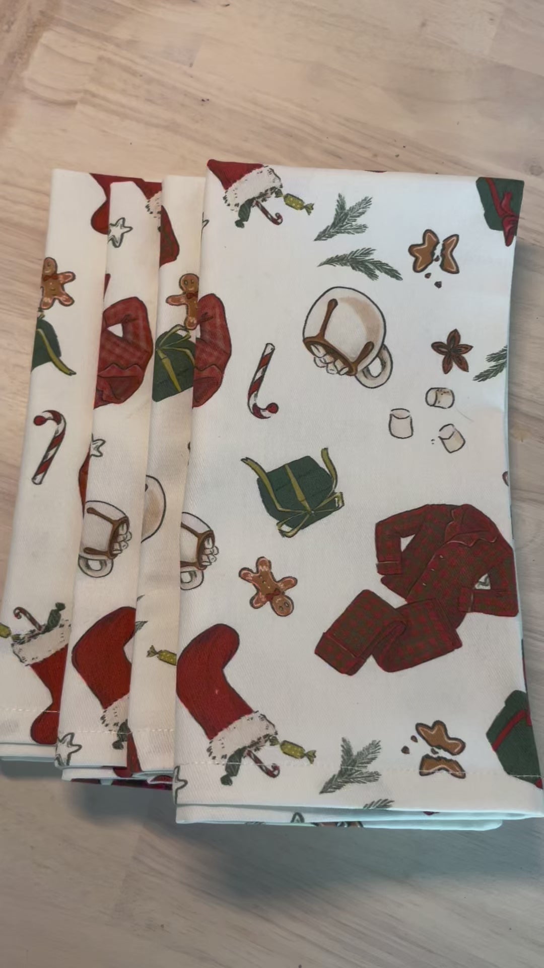Festive cotton napkins featuring cozy Christmas morning scene with stockings, wrapped gifts, cocoa, and cookies.